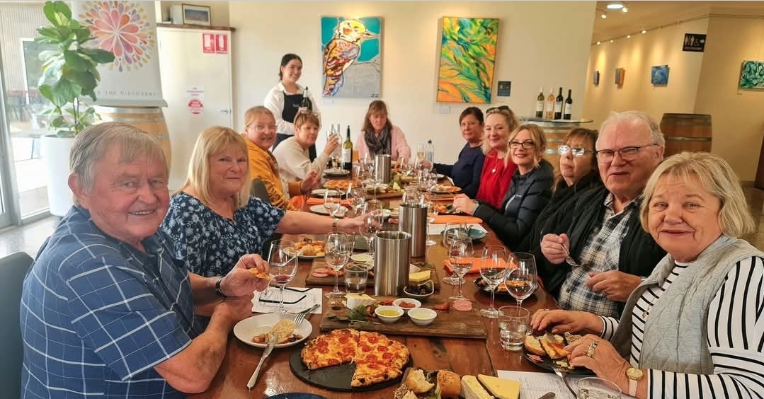 Group enjoying winery lunch with wine and food